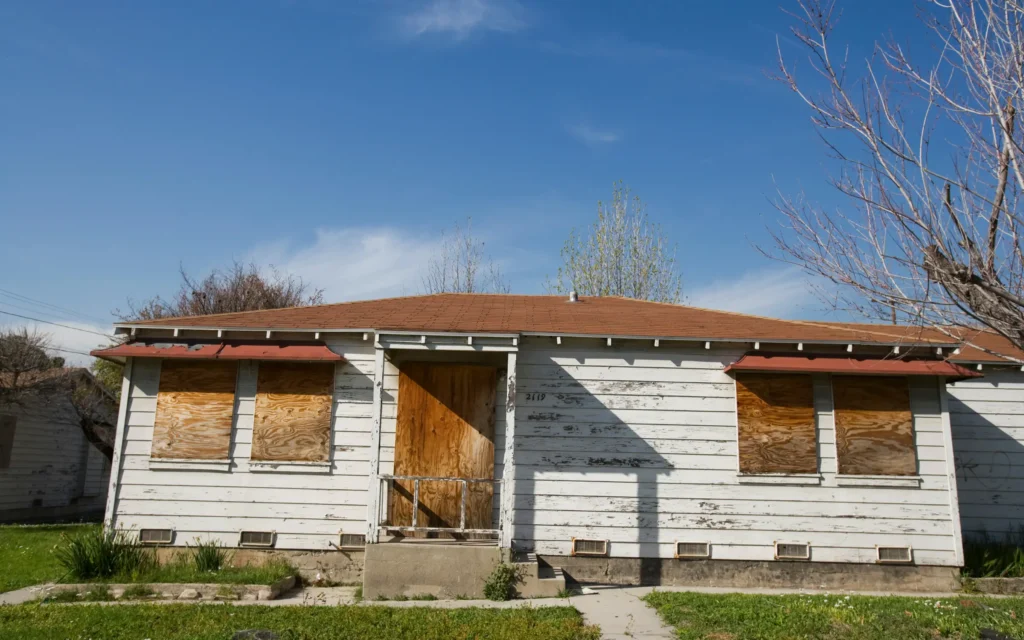 A home with windows and doors fully boarded up, representing emergency board up services in Maryland