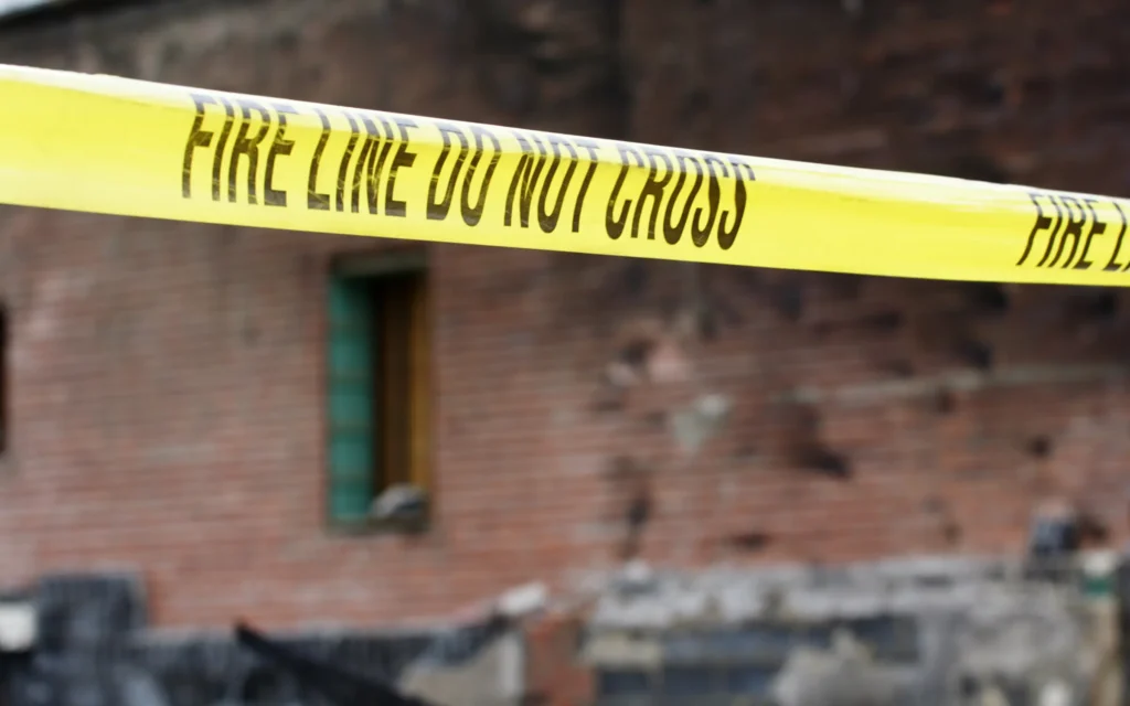A taped off area reading "fire line do not cross", representing safe cordoning of an area for structural assessment after fire damage