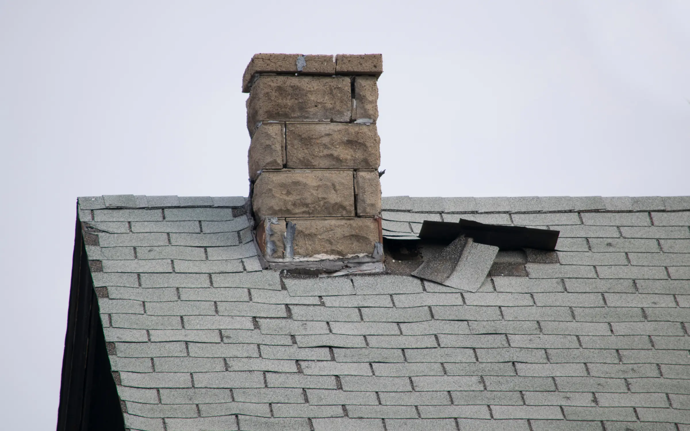 A roof with damaged shingles representing wind damage repairs in Maryland