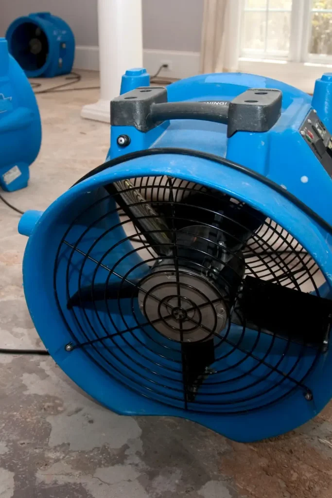 Drying fans set up inside a home after water damage